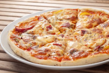 Normal dilimlenmiş sığır eti pizzası bir tabağa konur ve yemeye hazırdır.