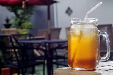 Plastik kamışla servis edilen bir bardak buzlu çay.