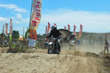 Probolinggo, Endonezya - 8 Temmuz 2012: Bir motosiklet çapraz yarışçısı tozlu bir pistte pratik yapıyor