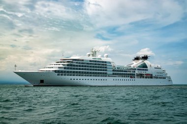 Bulutlu gökyüzünün altında yelken açan bir gemi..