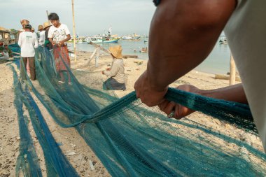 Probolinggo, Endonezya - 30 Kasım 2014: Gili Adaları 'ndaki köylülerin günlük faaliyetleri denizde balık tutmak için kullanılmadan önce balık ağlarını onarıyor