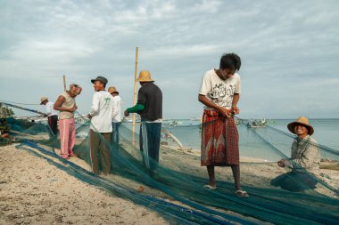 Probolinggo, Endonezya - 30 Kasım 2014: Gili Adaları 'ndaki köylülerin günlük faaliyetleri denizde balık tutmak için kullanılmadan önce balık ağlarını onarıyor