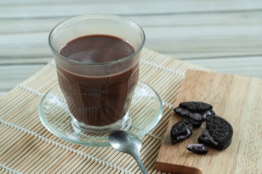 Amerikan kahvesi bambu masasına konmuş bardakta servis edilir ve çikolata parçacıklarıyla servis edilir.