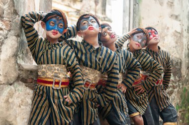 Ngawi, Endonezya - 24 Kasım 2013: Bazı çocuklar sevimli maskeler gibi maskeli geleneksel Cava kıyafetleri giyerler. Sanat gösterisi başlamadan önce poz vermişler.