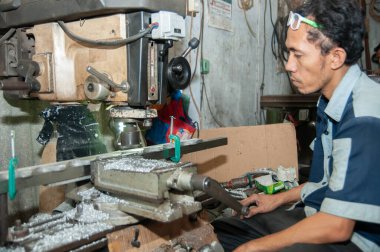 Pasuruan, Endonezya - 16 Ocak 2014: Torna atölyesi çalışanları metal işçiliği yapıyor