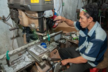Pasuruan, Endonezya - 16 Ocak 2014: Torna atölyesi çalışanları metal işçiliği yapıyor