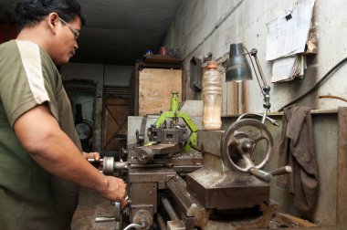 Pasuruan, Endonezya - 17 Ocak 2014: Torna atölyesi işçisi metal sondajı yapıyor