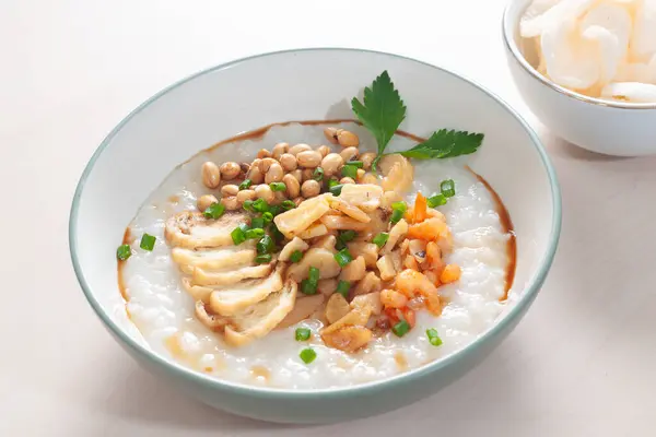 Bubur Manggul Seafood Madura or Madurese Seafood Porridge. Consist of White rice porridge, shrimp and sliced fried egg with soybean