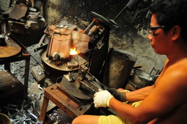 Pasuruan, Endonezya - 1 Mart 2013: döküm işçileri küflere erimiş metal döküyorlar
