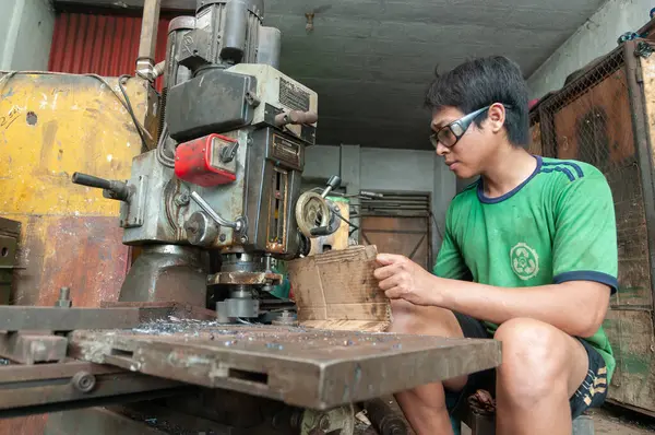 Pasuruan, Endonezya - 17 Ocak 2014: Torna atölyesi çalışanları metal işçiliği yapıyor