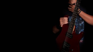 Stüdyoda elektro gitar çalan bir erkek. koyu arkaplanda izole