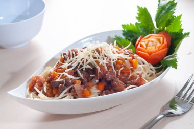 Peynirli bolonez beyaz arka planlı beyaz bir tabağa serpiştirilir.