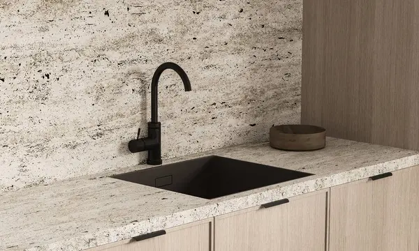 Parlak siyah bir mutfak lavabosunun yakın çekimi ve granit bir tezgahın üzerindeki musluk çağdaş bir mutfakta desenli bir geri sıçrama..