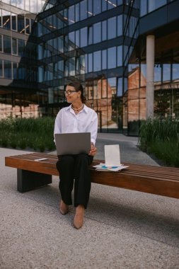 Açık havada çalışan, üretkenlik ve modern çalışma tarzı sergileyen bir iş adamı..
