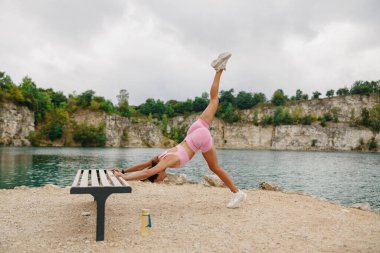 Huzurlu bir göl kenarında çeşitli yoga pozları veren bir kadın, spor ve genel sağlığını etkin bir şekilde destekliyor.