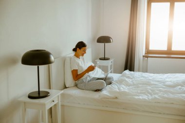 Huzurlu bir yatak odası, rahat ve davetkar bir atmosferde rahatlama ve bencilliğin önemini vurgular.