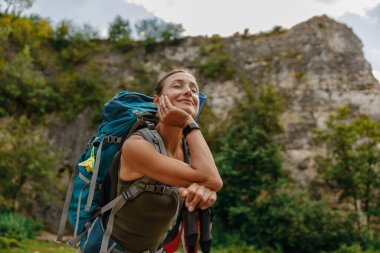 Neşeli bir yürüyüşçü neşe içinde doğayı kucaklar çarpıcı güzelliği, geniş bir sırt çantası taşırken yemyeşil, canlı manzaralar
