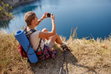 Yürüyüşçüler nefes kesici bir gölün fotoğraflarını çeker. Güzellik ve macera heyecanı sergilerler.