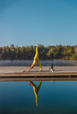 Huzurlu bir yoga duruşu sakin sularda, güzel bir denge ve doğa ile uyum içinde.