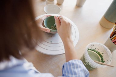 Deneyimli bir sanatçı güzel çömlek şekillendiriyor, olağanüstü yaratıcılık ve ustalık sergiliyor.