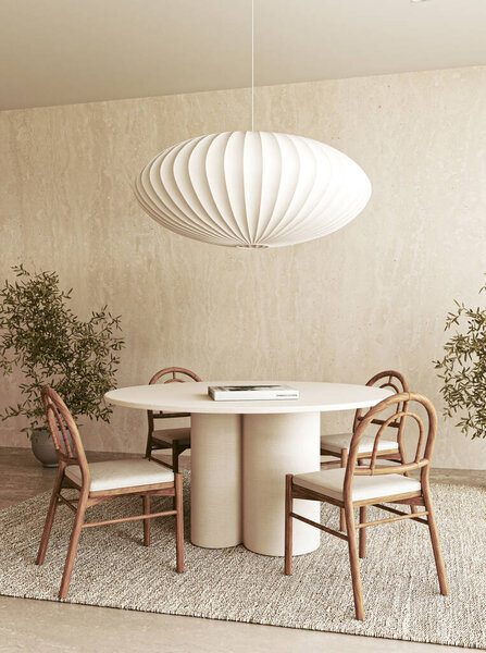 A sleek dining area designed with a round table, elegant chairs, and a stunning unique pendant light hanging above