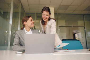 İki yetenekli profesyonel kadın, modern ofis ortamında çalışma konusunda dinamik bir tartışmaya giriştiler.