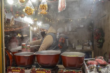 Barmen, Noel pazarında sıcak şarap, meyve ve baharat servisi yapıyor.