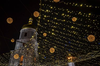 Ukrayna 'nın başkenti Kyiv' de yeni yıl kutlamaları sırasında arka planda Noel süslemeleri ve aydınlatılmış Aziz Sophia Katedrali