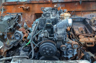 Close-up of burnt rusty engine in russian military vehicle after combat strike