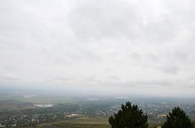 Gürcistan 'ın Kakheti bölgesinde sonbahar sisli bir günde tarlaları ve üzüm bağlarıyla Alazani Vadisi manzarası