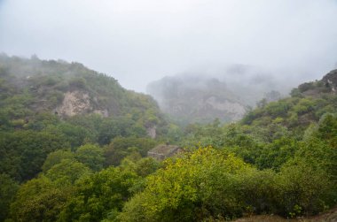 Ermenistan 'ın en etkileyici ve gizemli yerlerinden biri olan Khndzoresk Mağara şehrinin sisi ile kaplı derin bir vadinin dik yamaçları.