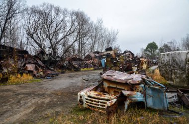 Hurdalıkta hurdaya dönmüş eski paslı araba yığınları geri dönüşüme hazır.