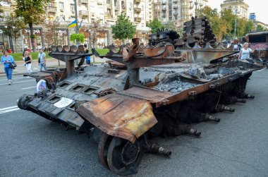 İnsanlar, Kyiv 'in merkezindeki Khreshhatyk Caddesi' ndeki Rus işgal güçlerinin hasar görmüş ve ele geçirilmiş askeri teçhizatını inceliyor.