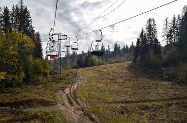 Renkli ağaçlarla dolu bir dağ yamacında boş bir saç kaldırma. Sonbahar sezonunda asansör. Karpat Dağları, Ukrayna