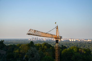 Tower crane on the background of Dnipro river and left bank of Kyiv city. New buildings architecture and industry construction