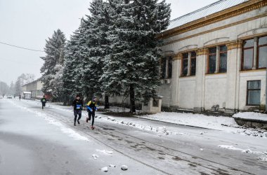 Group of athletes runners run city marathon on a frosty winter day. Sport, fitness and healthy lifestyle concept