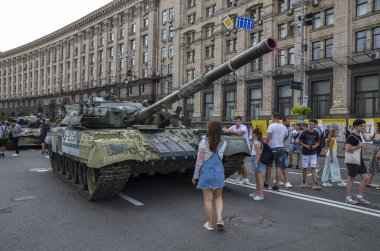 People inspect the damaged and captured military tank of the Russian occupying forces on Khreshchatyk Street in the center of Kyiv