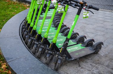 Row of city Electric Scooters parked on the street for rent. Eco transport concept for every day