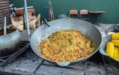 Büyük bir kazanda et, pirinç ve sebzelerle dolu bir pilav. Sokak yemekleri konsepti