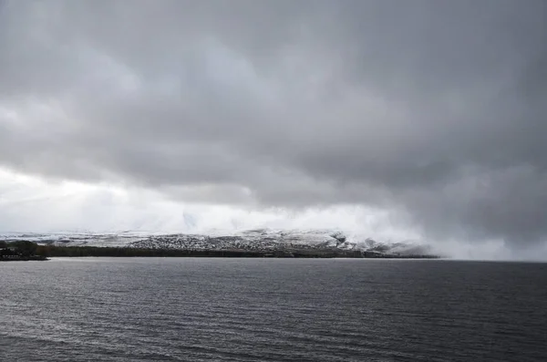 Серая Водная Поверхность Озера Севан Фоне Заснеженных Гор Бурным Небом — стоковое фото