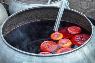 Sıcak sıcak şarap ve portakal dilimleri bir kazanda Açık havada tatil caddesi gıda pazarında