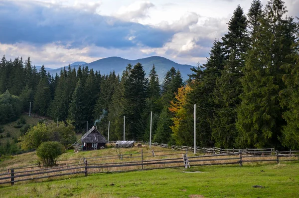 stock image Cozy little wooden house on the green hills surrounded forest and mountains. Carpathian Mountains, Ukraine