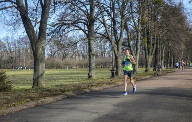 Doğada koşan atletik genç adam. Dinamik hareket. Kentsel sağlıklı aktif yaşam tarzı