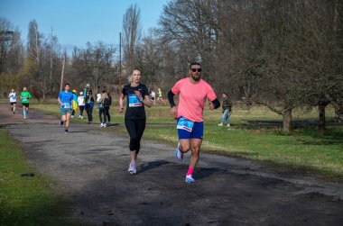 Yaz parkında asfalt yolda koşan aktif bir erkek ve kadın. Sağlıklı yaşam tarzı kavramı