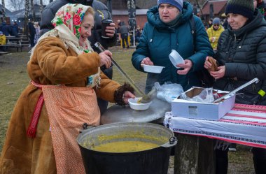 Kadın insanlara kulish ile davranıyor. Asırlık bir Ukrayna yemeği, çömlek, darı, salo, patates ve soğandan yapılmış Zaporizhian Kazakları tarafından popüler hale getirilmiş.