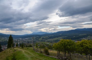 Orman tepeleri ve vadideki Karpatya köyü ile güzel bir manzara. Yazın Karpat Dağları