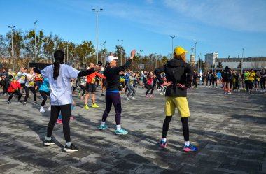 Bir grup koşucu maratonda koşmadan önce ısınıyor ve esniyorlar.