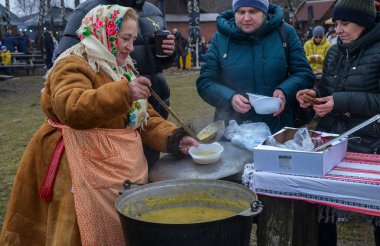 Kadın insanlara kulish ile davranıyor. Asırlık bir Ukrayna yemeği, çömlek, darı, salo, patates ve soğandan yapılmış Zaporizhian Kazakları tarafından popüler hale getirilmiş.