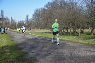 Spor giyim ve koşu ayakkabıları olan bir koşucu. Şehir sokaklarında maraton yaparken. Fitness ve sağlıklı yaşam tarzı konsepti 