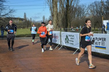 İnsanlar asfalt yolda sokak maratonunda koşuyorlar. Koşucular koşu, spor ve egzersiz, yarış ve yarışma